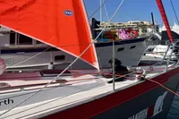 Custom Tasman 48 sailboat with vibrant red sails docked at marina, 1999 model.