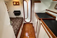 Interior of 1999 Custom Tasman 48 yacht with wood flooring and compact cabin design.