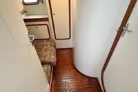 Interior of 1999 Custom Tasman 48 yacht with wooden flooring and cushioned seating.