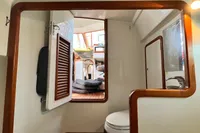 Interior of 1999 Custom Tasman 48 yacht, featuring a compact bathroom and wooden accents.