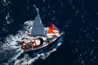Aerial view of a 1999 Custom Tasman 48 sailboat navigating through deep blue ocean waters.