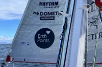 Sailboat with branded sails on the water, featuring Rhythm Snowsports and Dometic Outdoor logos.