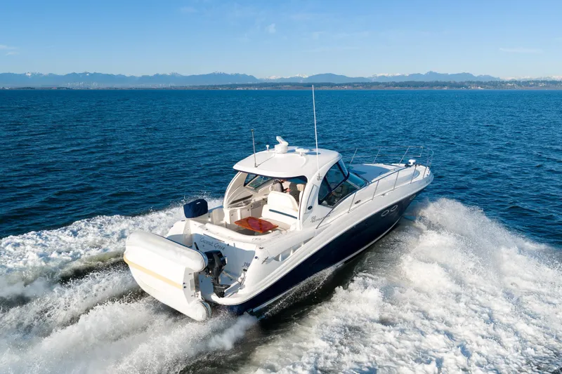  Yacht Photos Pics 2004 Sea Ray 390 Sundancer cruising on open water with scenic mountain backdrop.
