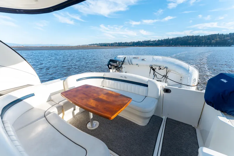  Yacht Photos Pics 2004 Sea Ray 390 Sundancer yacht interior with seating and table, cruising on a scenic lake.