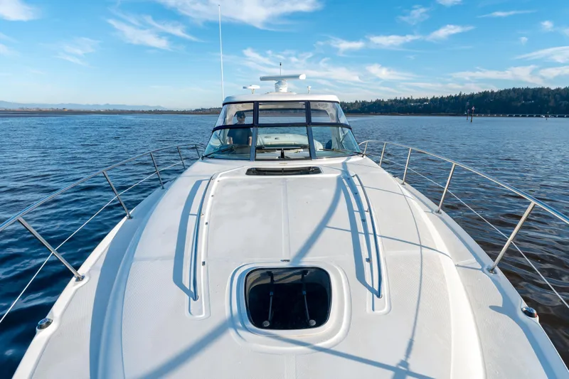  Yacht Photos Pics 2004 Sea Ray 390 Sundancer yacht cruising on a serene lake under a clear blue sky.