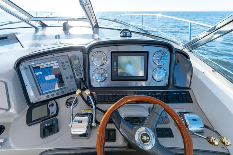  Yacht Photos Pics Helm of 2004 Sea Ray 390 Sundancer with navigation equipment and wooden steering wheel.