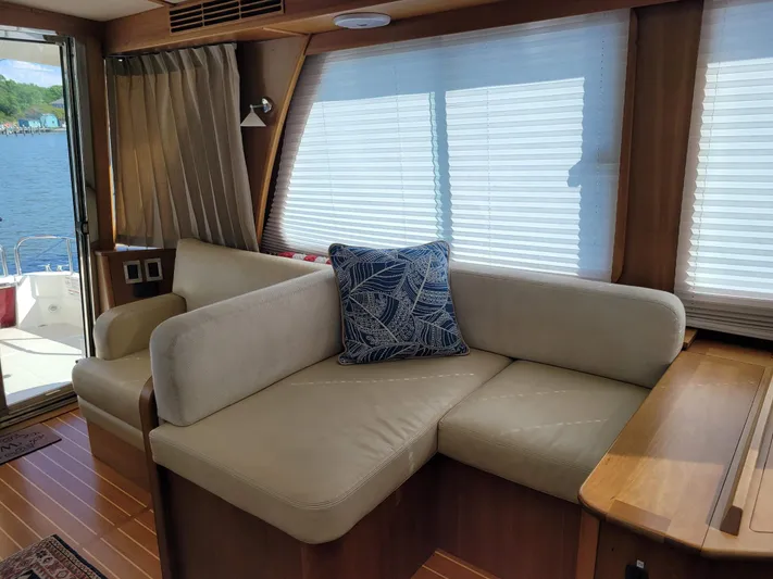 The Dark Side Yacht Photos Pics Interior of 2014 Sabre 48 Salon Express with beige sofa and nautical pillow.