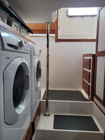 The Dark Side Yacht Photos Pics Laundry area in 2014 Sabre 48 Salon Express yacht with stairs and storage cabinets.