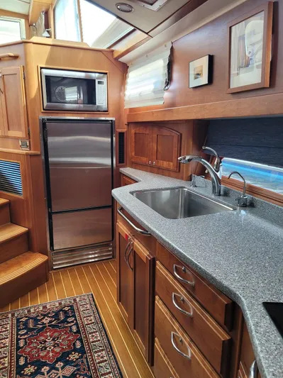 The Dark Side Yacht Photos Pics 2014 Sabre 48 Salon Express kitchen with stainless steel appliances and wooden cabinetry.
