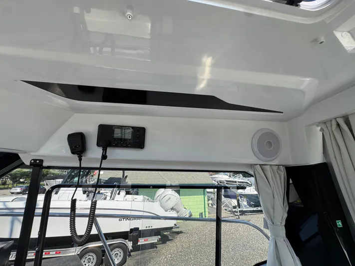  Yacht Photos Pics Interior view of 2025 Jeanneau NC 795 Series 2 boat, featuring communication equipment and speaker.