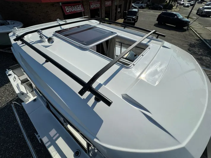  Yacht Photos Pics 2025 Jeanneau NC 795 Series 2 boat roof with sunroof and railings, parked outdoors.