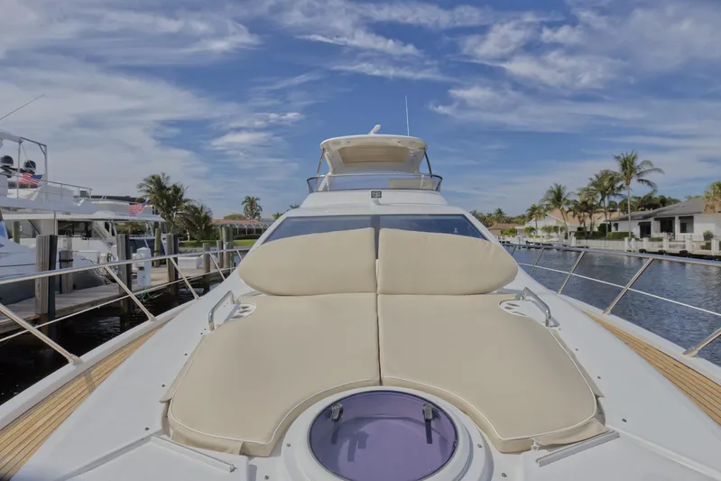 Neena Yacht Photos Pics 2015 Azimut 64 Flybridge yacht with sunbathing area, docked in a marina.