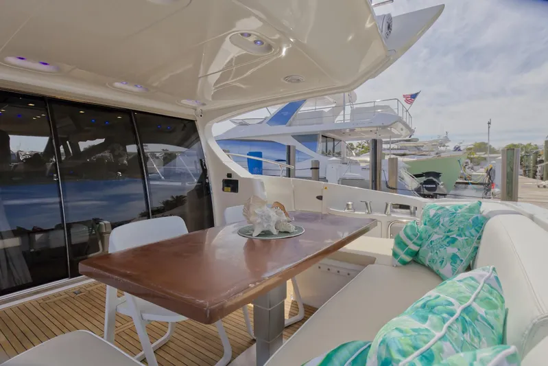 Neena Yacht Photos Pics 2015 Azimut 64 Flybridge yacht with outdoor dining area and marina view.