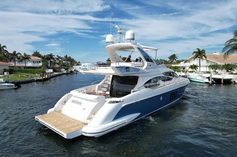Neena Yacht Photos Pics 2015 Azimut 64 Flybridge yacht cruising in a scenic waterfront neighborhood.