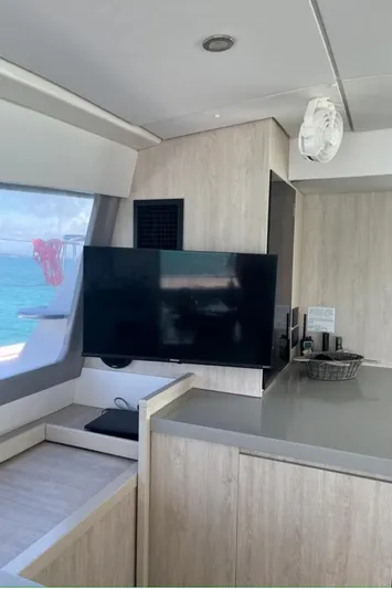  Yacht Photos Pics Modern interior of a 2018 Leopard 40 catamaran with a flat-screen TV and light wood finishes.