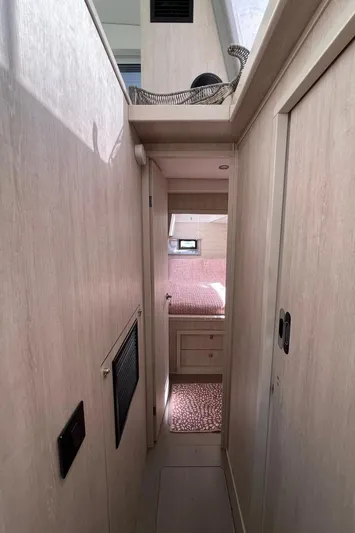  Yacht Photos Pics Interior hallway of a 2018 Leopard 40 catamaran, featuring light wood paneling and cozy cabin access.