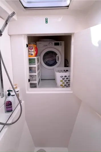  Yacht Photos Pics Laundry area in a 2018 Leopard 40 yacht with washer, storage, and shower essentials.