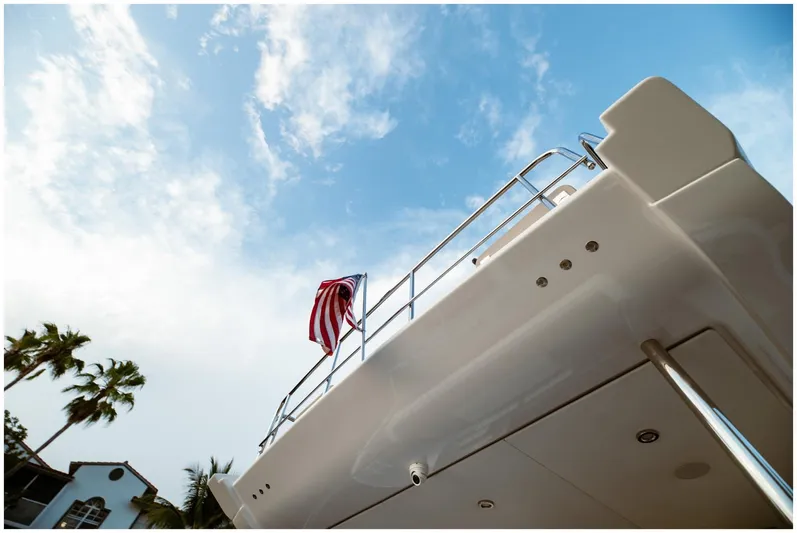  Yacht Photos Pics Azimut 2022 Fly yacht with American flag against blue sky background.