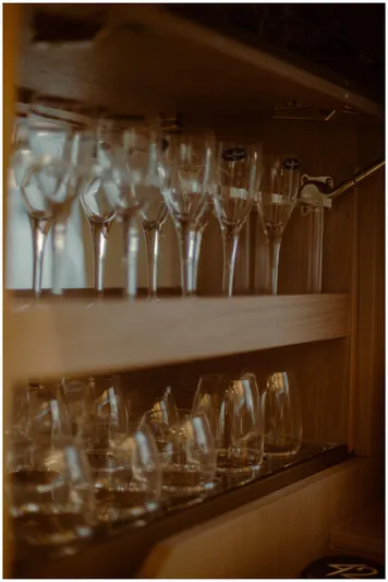  Yacht Photos Pics Wine glasses neatly arranged in a wooden cabinet on a 2022 Azimut Fly yacht.