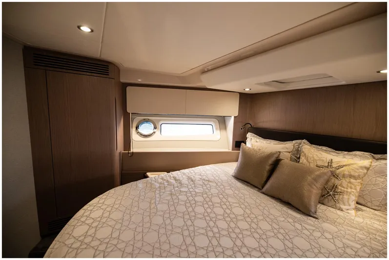  Yacht Photos Pics Luxurious bedroom interior of 2022 Azimut Fly yacht with elegant bedding and porthole window.