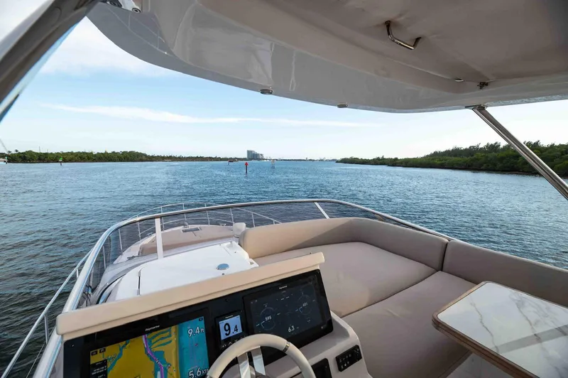  Yacht Photos Pics Azimut 50 Fly 2022 yacht interior with navigation system, cruising on a serene waterway.