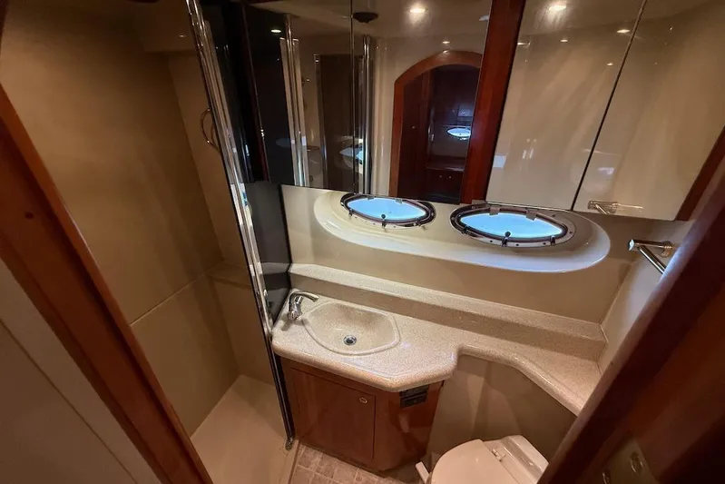 No Worries Yacht Photos Pics Luxurious bathroom in 2006 Cruisers Yachts 415 Express Motoryacht with porthole windows.