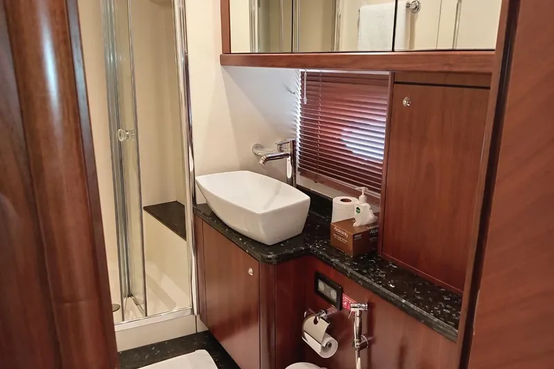  Yacht Photos Pics Luxurious bathroom in 2006 Sunseeker Predator 82 yacht with modern fixtures and wood accents.