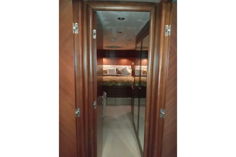  Yacht Photos Pics Interior view of 2006 Sunseeker Predator 82 yacht cabin with wooden doors and cozy bedding.
