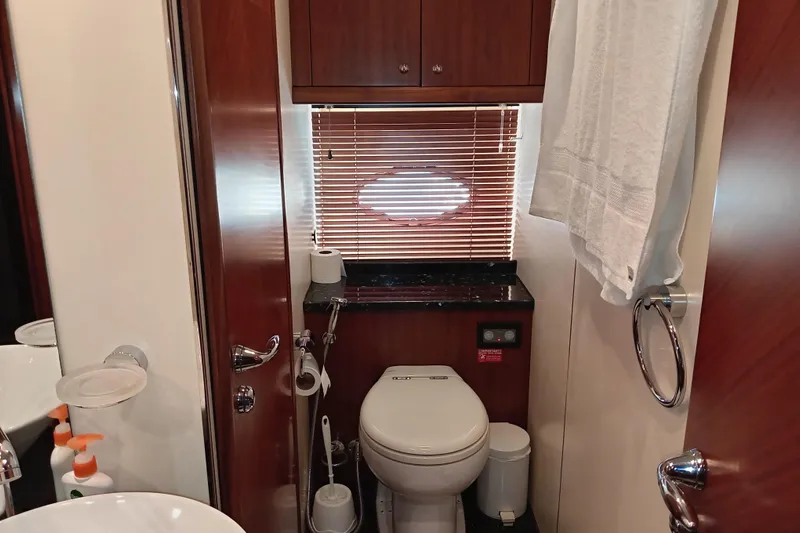  Yacht Photos Pics Luxurious bathroom in 2006 Sunseeker Predator 82 yacht with wooden cabinetry and modern fixtures.