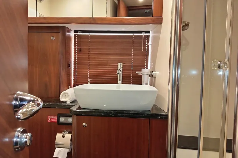  Yacht Photos Pics Luxurious bathroom interior of 2006 Sunseeker Predator 82 yacht with modern sink and wooden accents.
