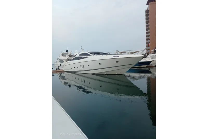  Yacht Photos Pics 2006 Sunseeker Predator 82 yacht docked in marina, reflecting on calm water.