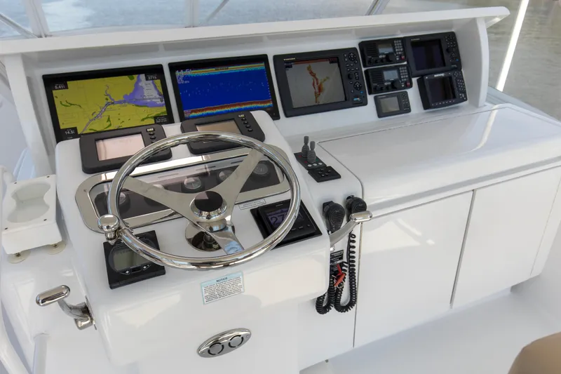 Lady A Yacht Photos Pics Control panel of 2008 Hatteras 54 Convertible yacht with navigation screens and steering wheel.