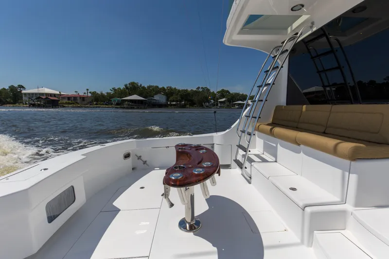 Lady A Yacht Photos Pics 2008 Hatteras 54 Convertible yacht deck with seating and ladder, cruising on a sunny day.