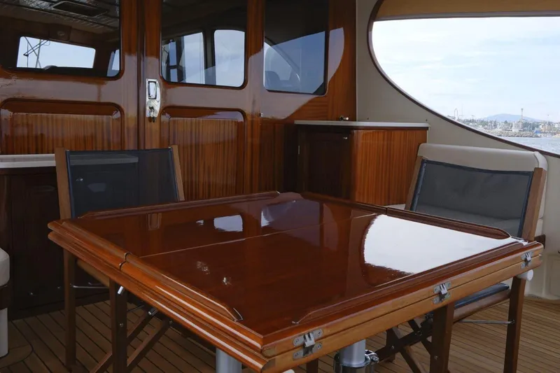  Yacht Photos Pics Luxurious interior of 2009 Vicem Classic 71 yacht with polished wood table and chairs.