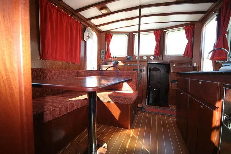  Yacht Photos Pics Interior of 2012 Sibma Navale Italiana Armstrong 12 boat with red curtains and wooden furnishings.