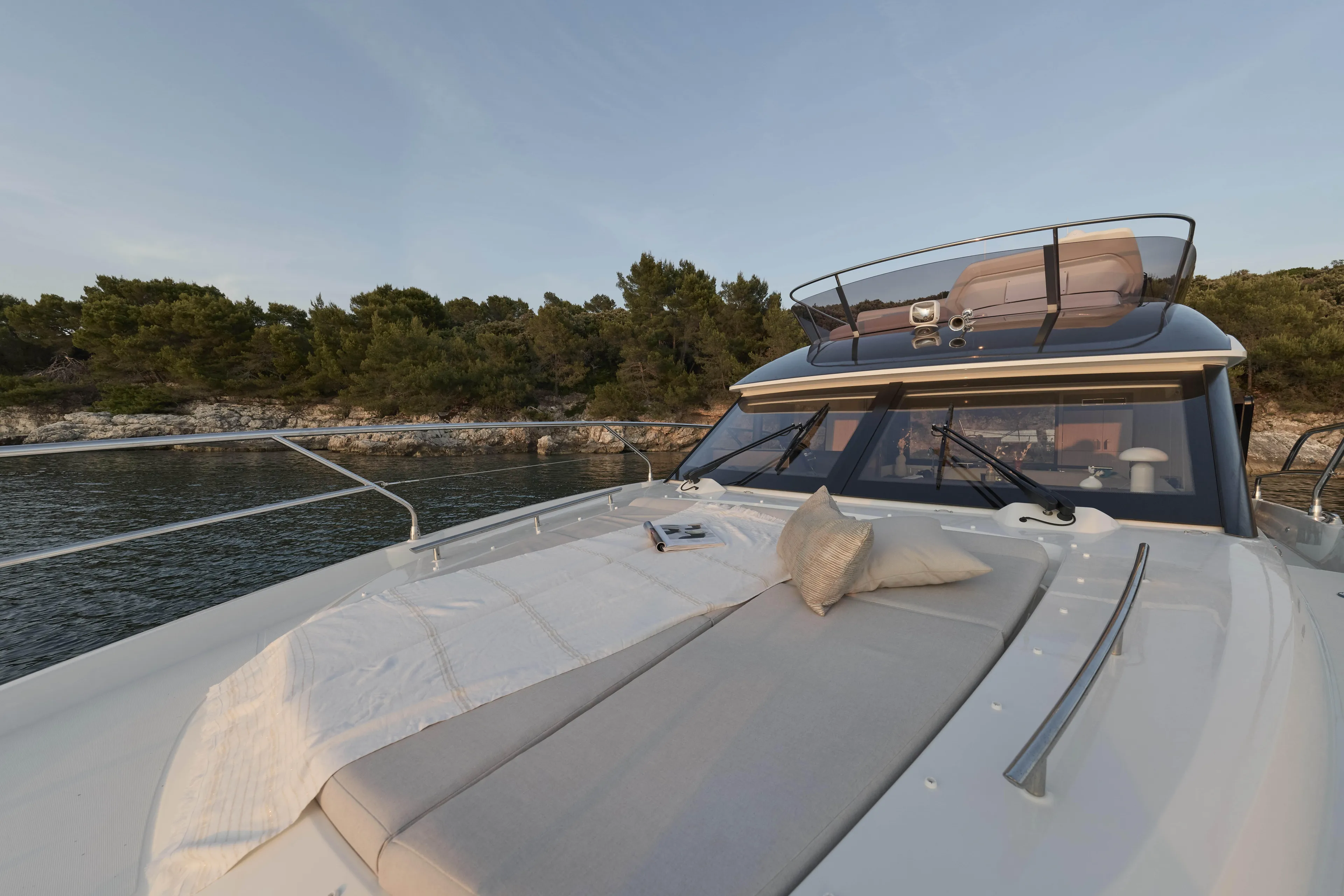  Yacht Photos Pics Luxurious 2026 Prestige F4.3 yacht with sunbathing deck, anchored near scenic shoreline.