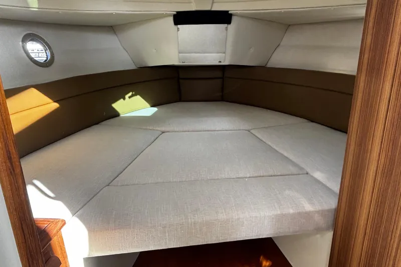  Yacht Photos Pics 2026 Ranger Tugs R-23 cabin interior with cozy bed and wooden accents.