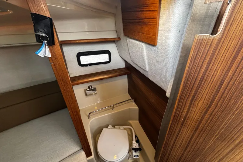  Yacht Photos Pics 2026 Ranger Tugs R-23 boat interior with compact bathroom and wooden accents.