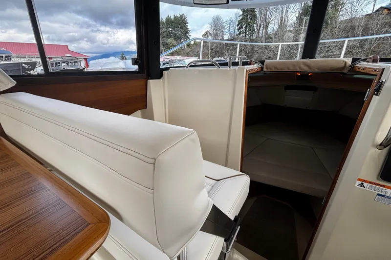  Yacht Photos Pics 2026 Ranger Tugs R-23 interior with white seating and cabin entrance.