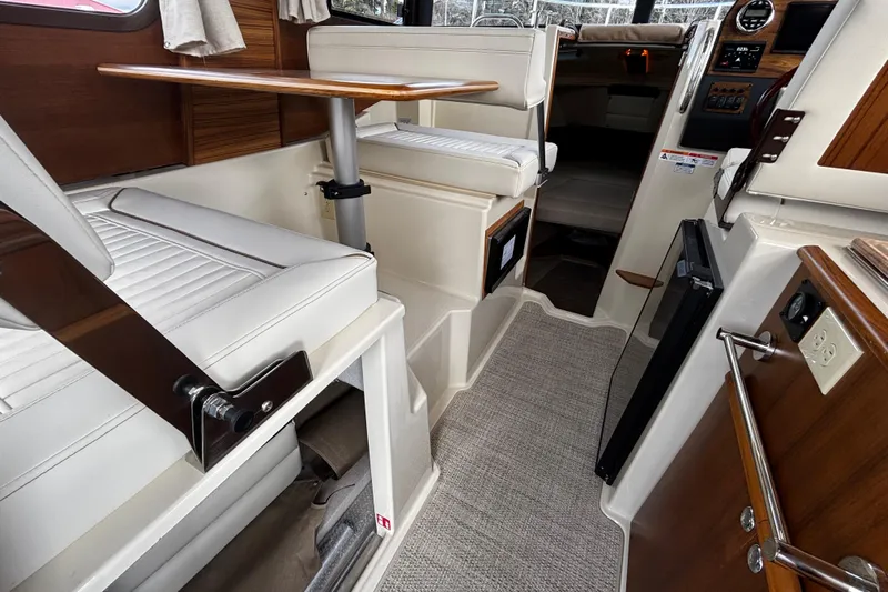  Yacht Photos Pics 2026 Ranger Tugs R-23 interior with white seating, wooden accents, and compact design.