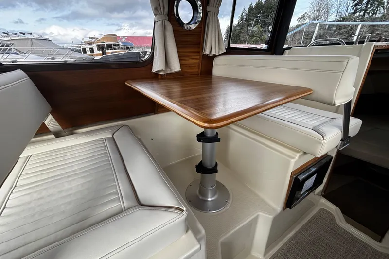  Yacht Photos Pics Interior of 2026 Ranger Tugs R-23 with elegant seating and wooden table.