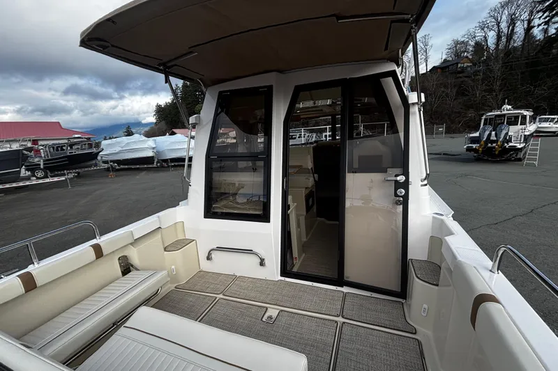  Yacht Photos Pics 2026 Ranger Tugs R-23 boat with open cabin door, docked in a marina.