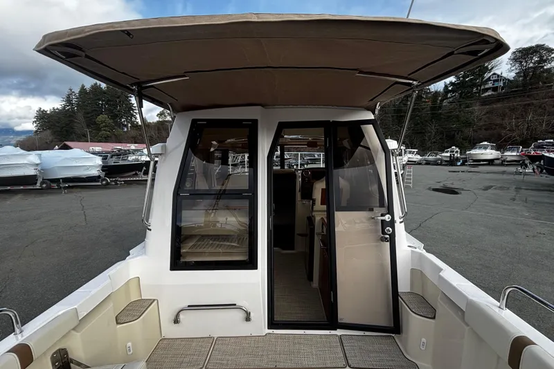  Yacht Photos Pics 2026 Ranger Tugs R-23 boat with open cabin door, docked at marina.