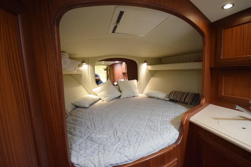  Yacht Photos Pics Cozy cabin interior of 2009 Jupiter 39 Express boat with comfortable bedding and wooden finish.