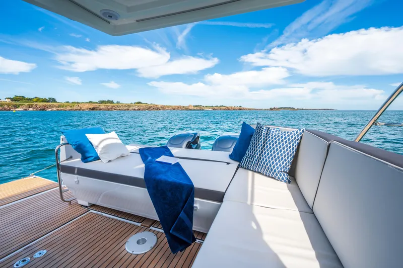  Yacht Photos Pics Luxurious seating on 2026 Beneteau Antares 11 Coupe yacht, with ocean view and blue sky.