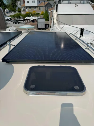 Fetch Yacht Photos Pics 2004 Mainship Pilot 34 with solar panel on deck, docked near other boats.