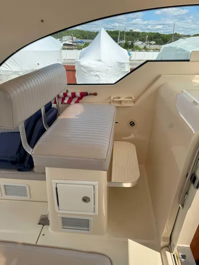 Fetch Yacht Photos Pics 2004 Mainship Pilot 34 interior with cushioned seating and storage, showcasing a sleek, nautical design.