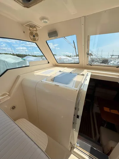 Fetch Yacht Photos Pics 2004 Mainship Pilot 34 interior with windows and seating, showcasing a bright, spacious cabin.