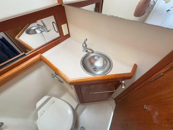 Fetch Yacht Photos Pics 2004 Mainship Pilot 34 bathroom with sink, mirror, and toilet.