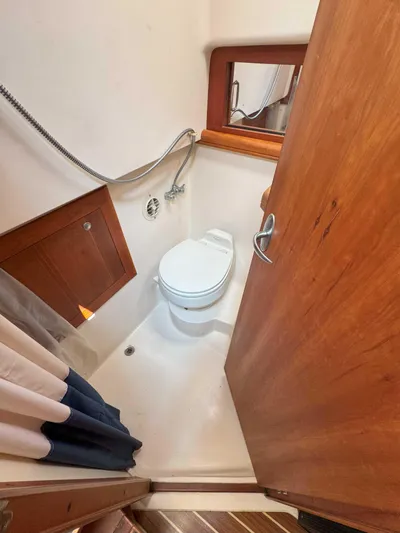 Fetch Yacht Photos Pics 2004 Mainship Pilot 34 bathroom with shower, toilet, and wooden door.
